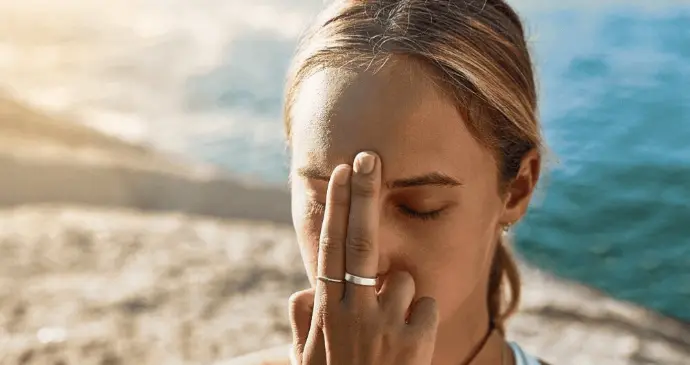 Femme pratiquant l’EFT, technique de libération émotionnelle par tapotement des méridiens du visage